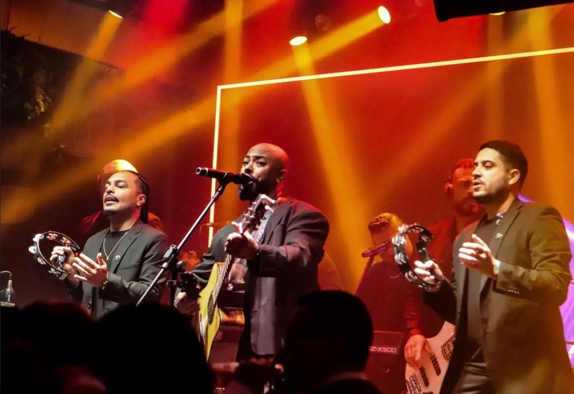 Trio da banda tocando pandeiro durante apresentação elegante