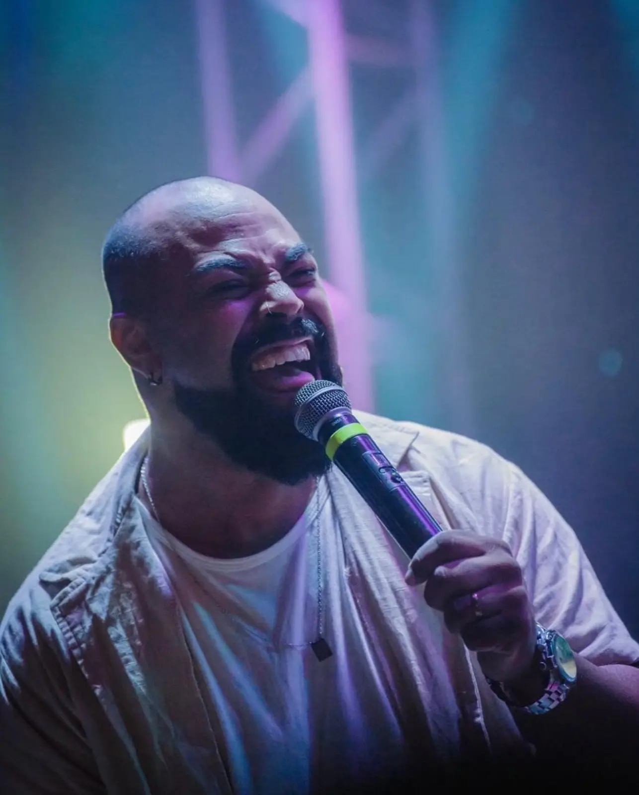 Maik Salgado cantando de perto sob luzes coloridas